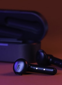 black and gray bluetooth earbuds