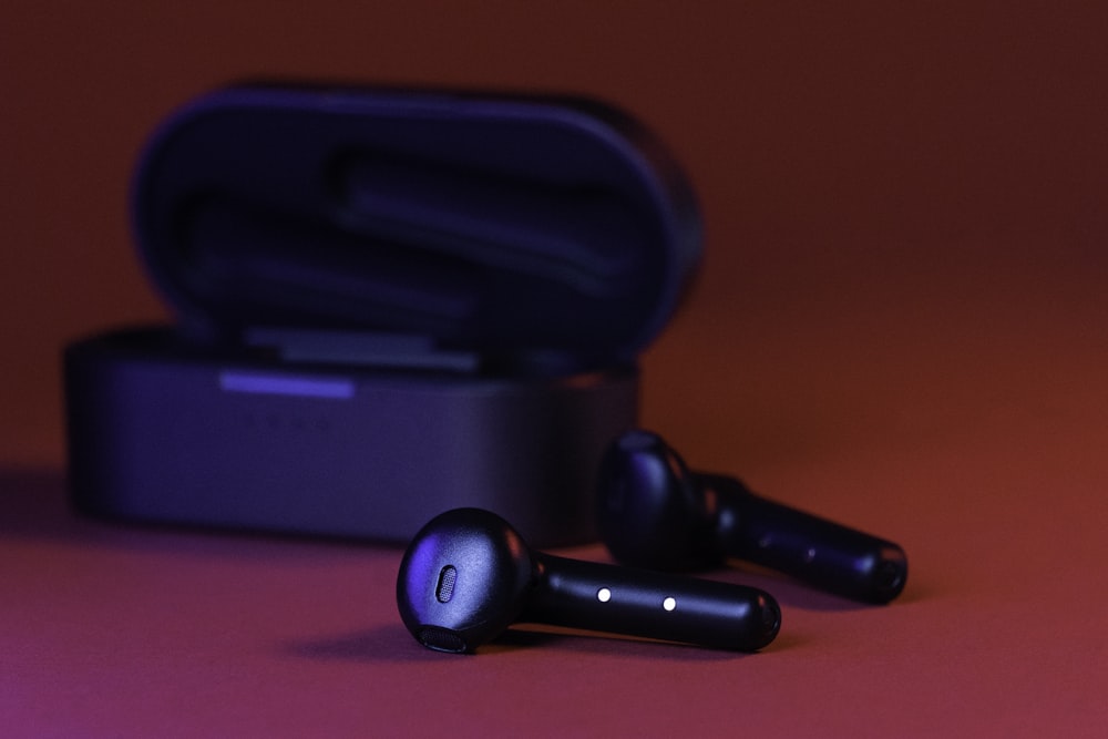 black and gray bluetooth earbuds