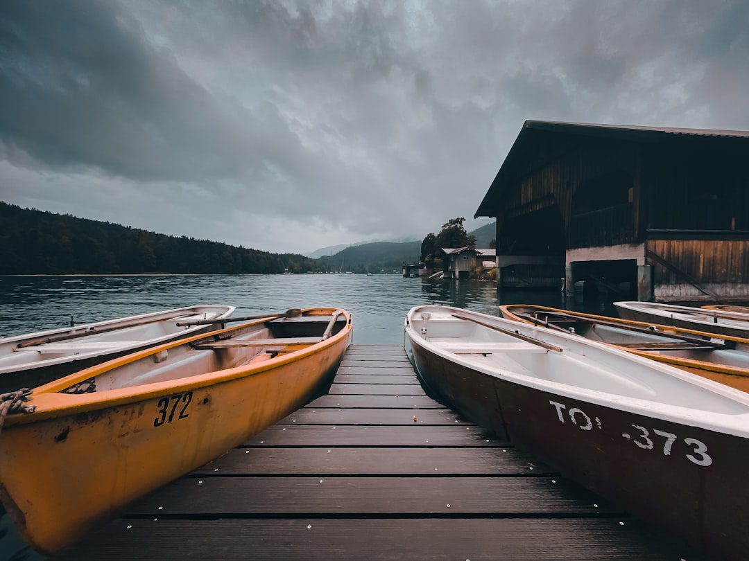 brown wooden dock near brown wooden house under white clouds during daytime