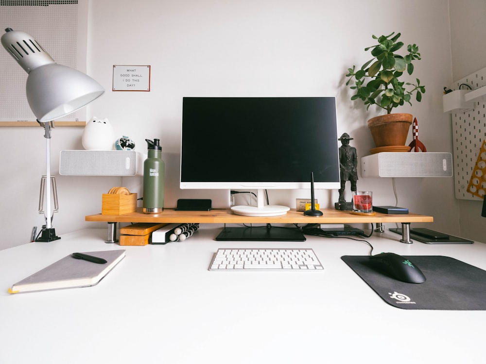 iMac argento su scrivania in legno bianco