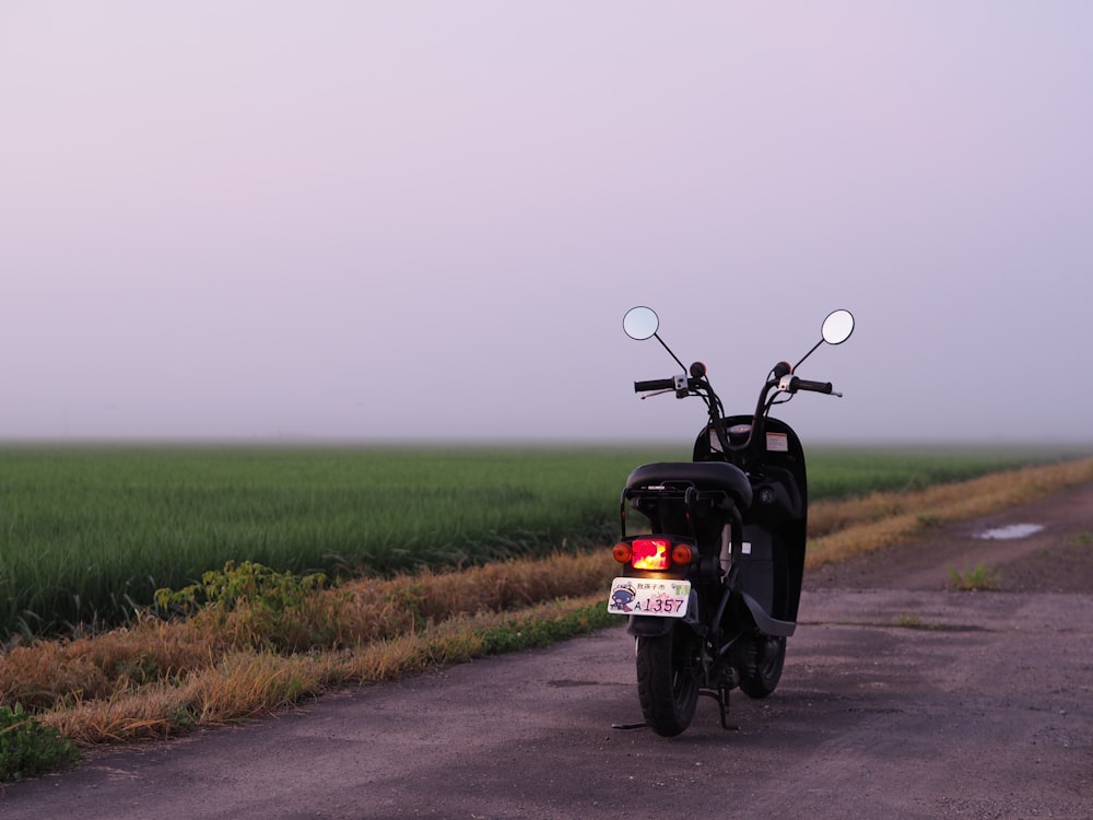 motocicleta negra en campo de hierba verde durante el día