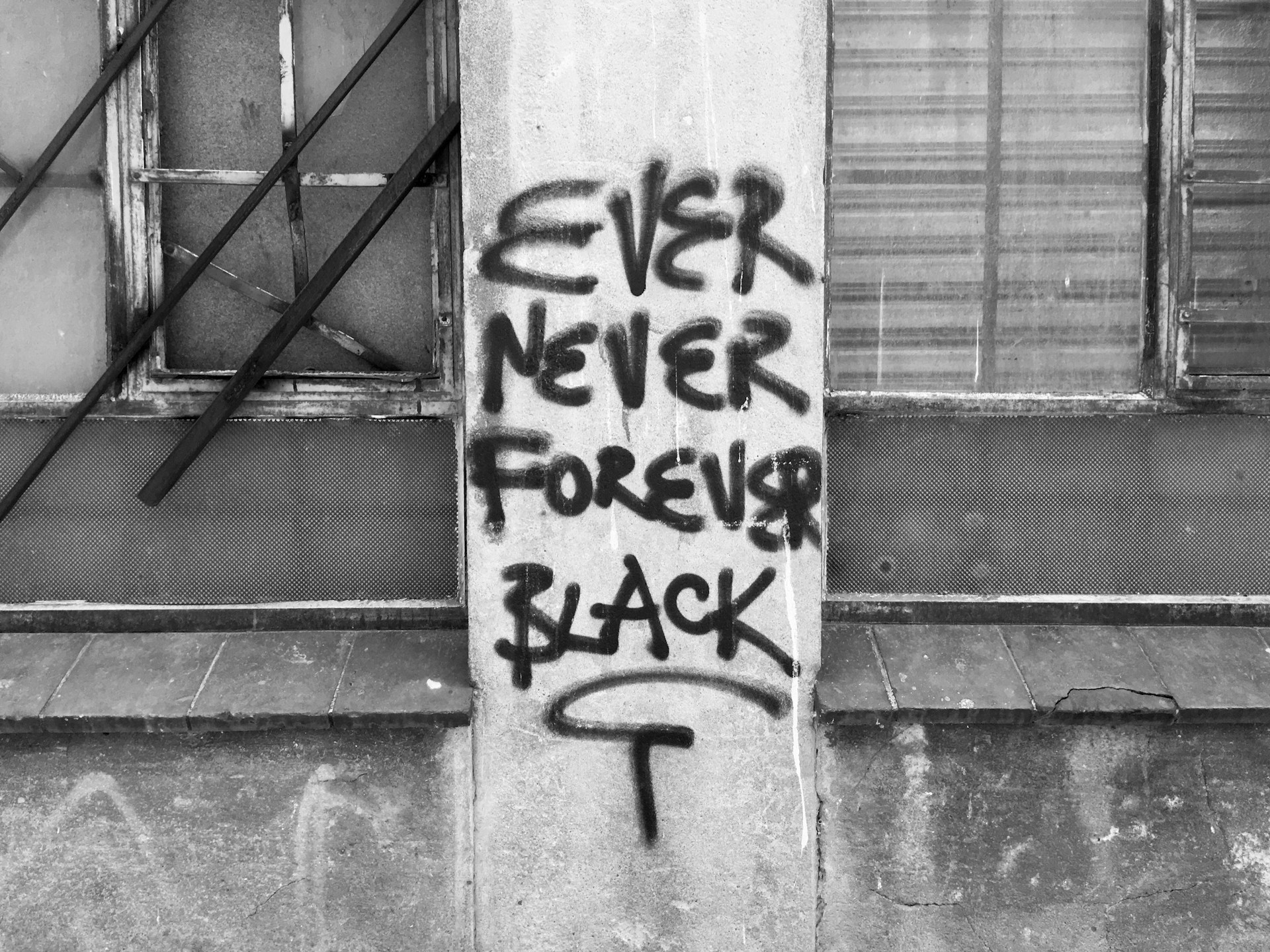 grayscale photo of wall with graffiti