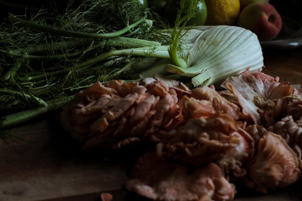 A close-up of fresh natural ingredients like herbs and berries arranged on a wooden table.