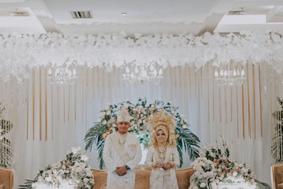 man in white suit sitting on chair