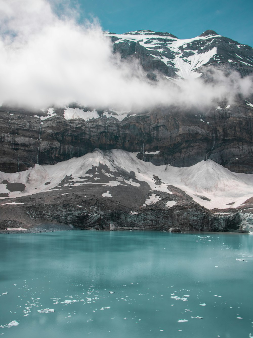 brown and white mountain near body of water during daytime