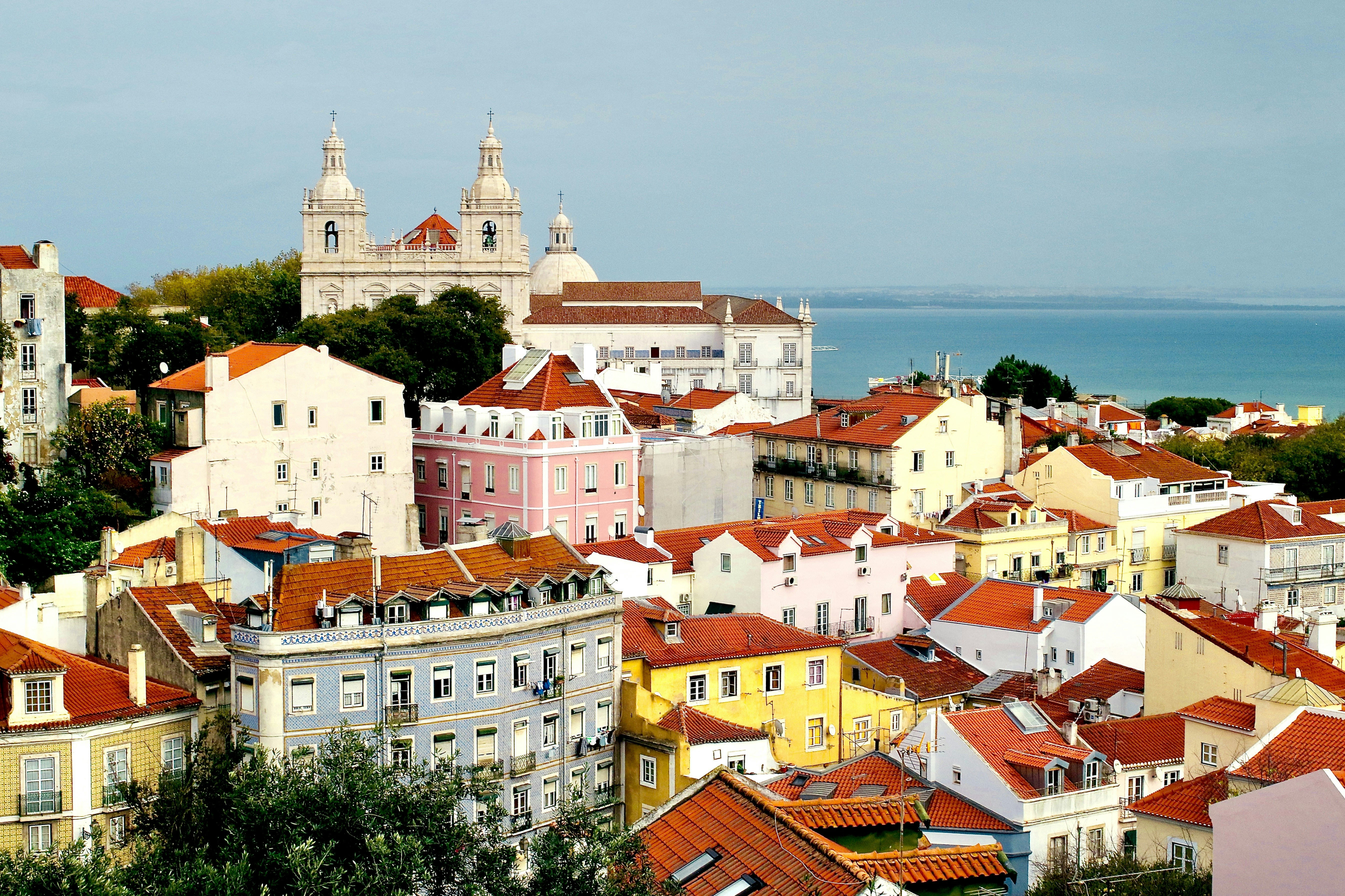 white and brown concrete houses near body of water during daytime