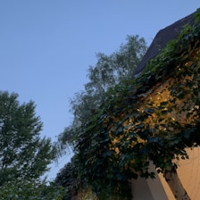 Evening view of the house’s terrace lit softly against a sunset sky.