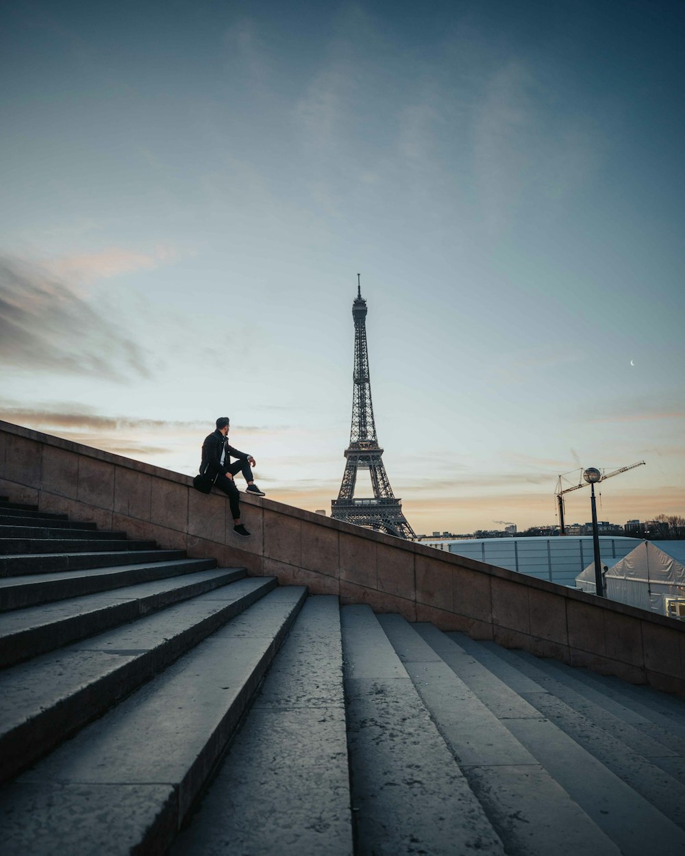 man in black jacket walking on gray concrete bridge during daytime