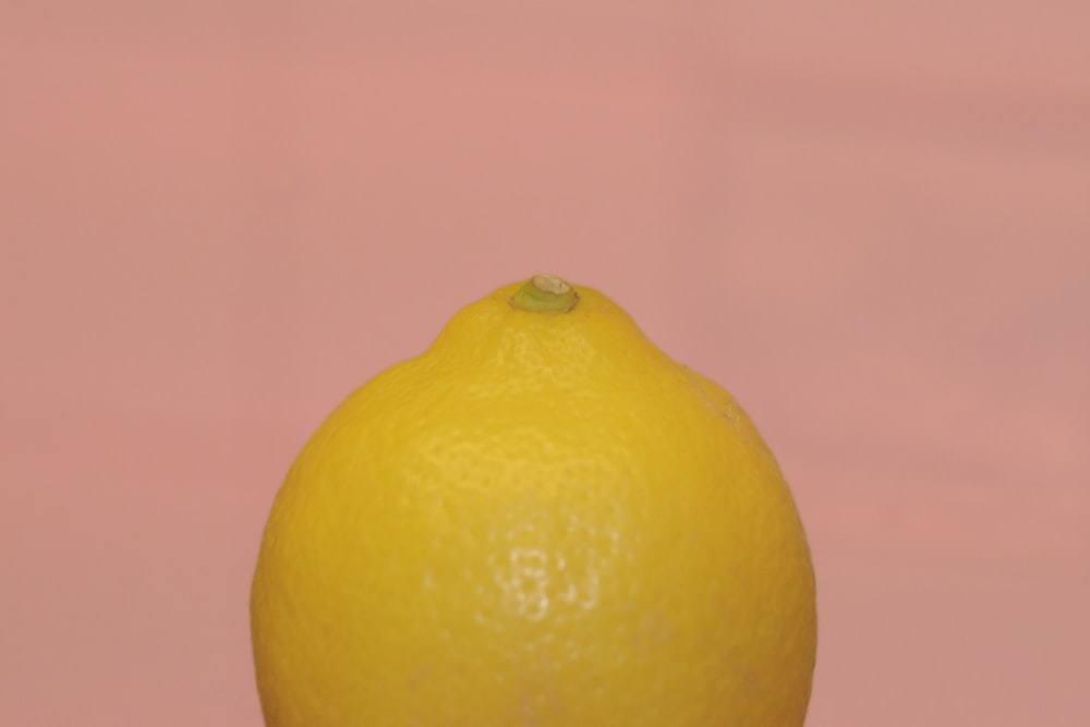 yellow lemon fruit on pink surface