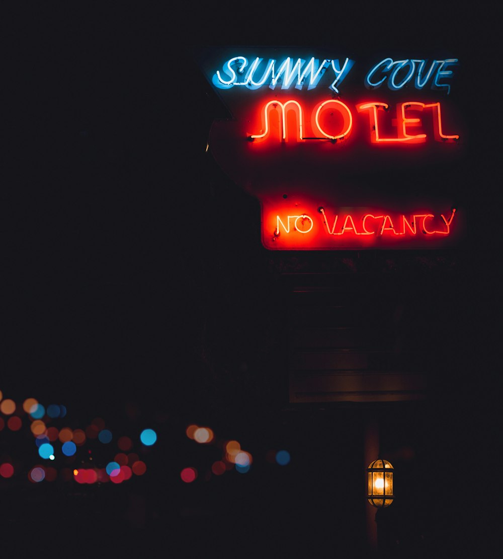 a motel sign lit up in the dark