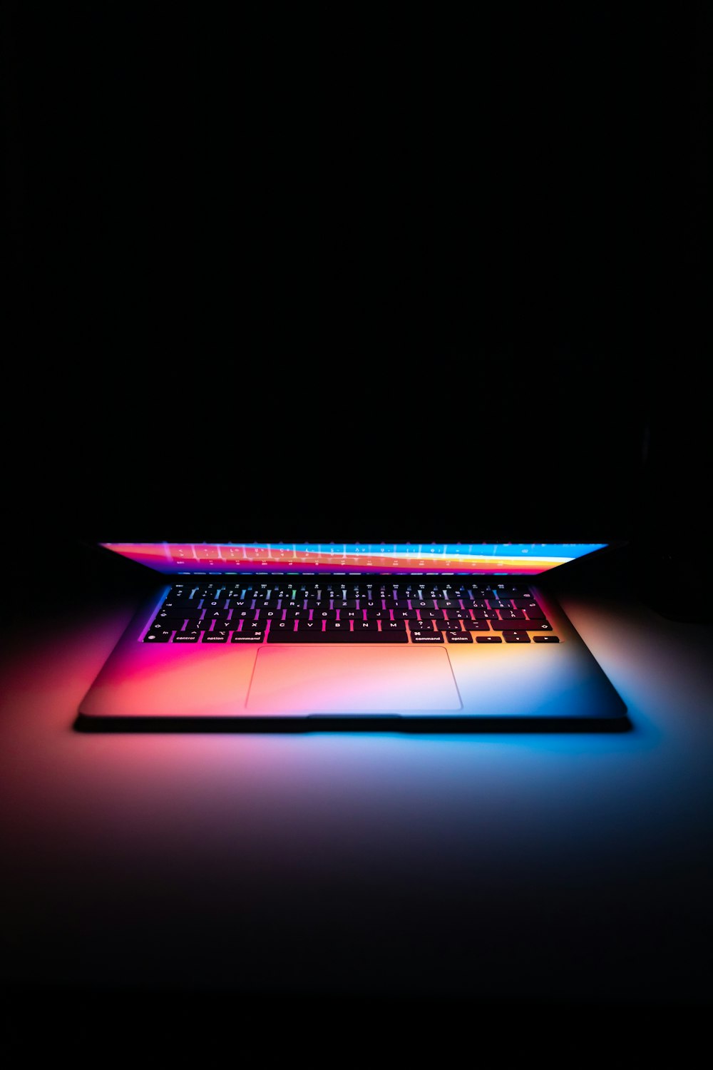 black laptop computer turned on in dim light