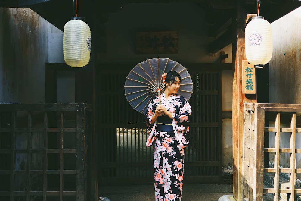 woman in black white and red floral kimono holding white and black umbrella