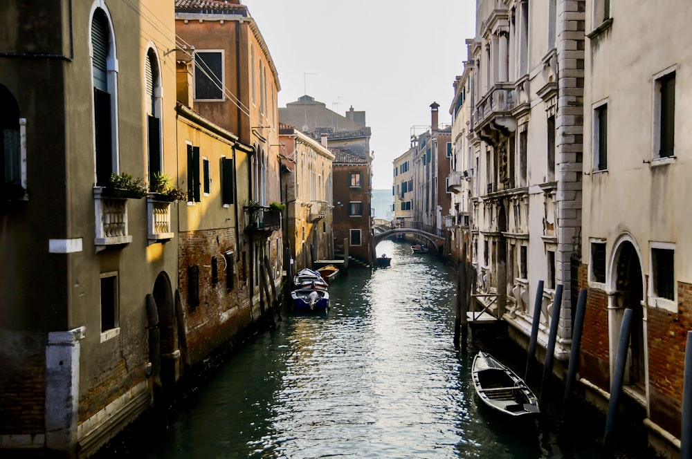 boat on river between buildings during daytime