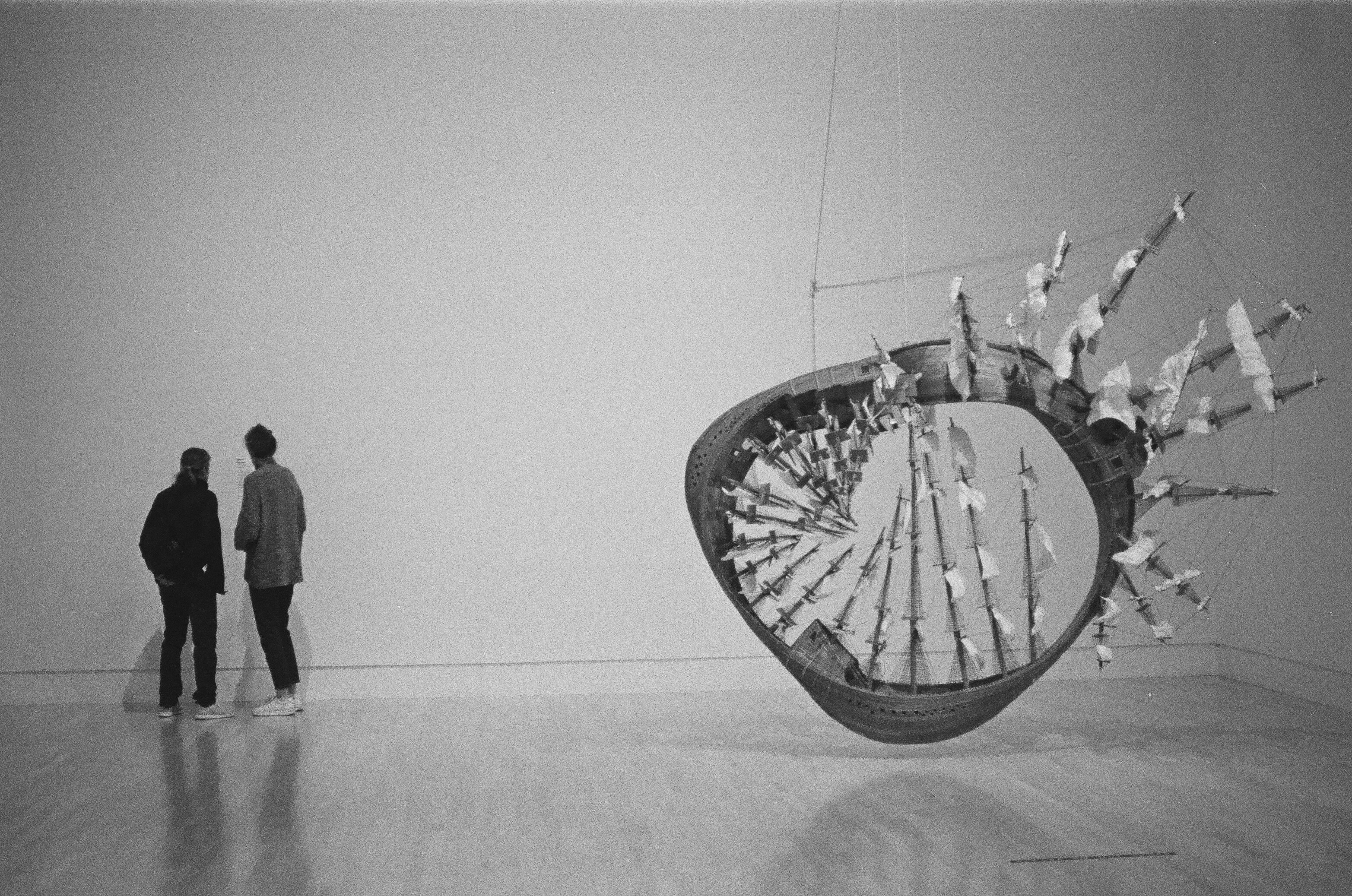 uomo in abito nero in piedi vicino al muro in bianco e nero