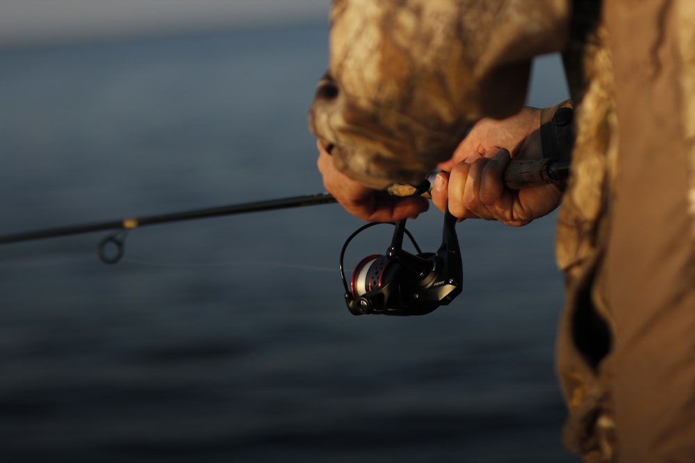 person holding black fishing rod