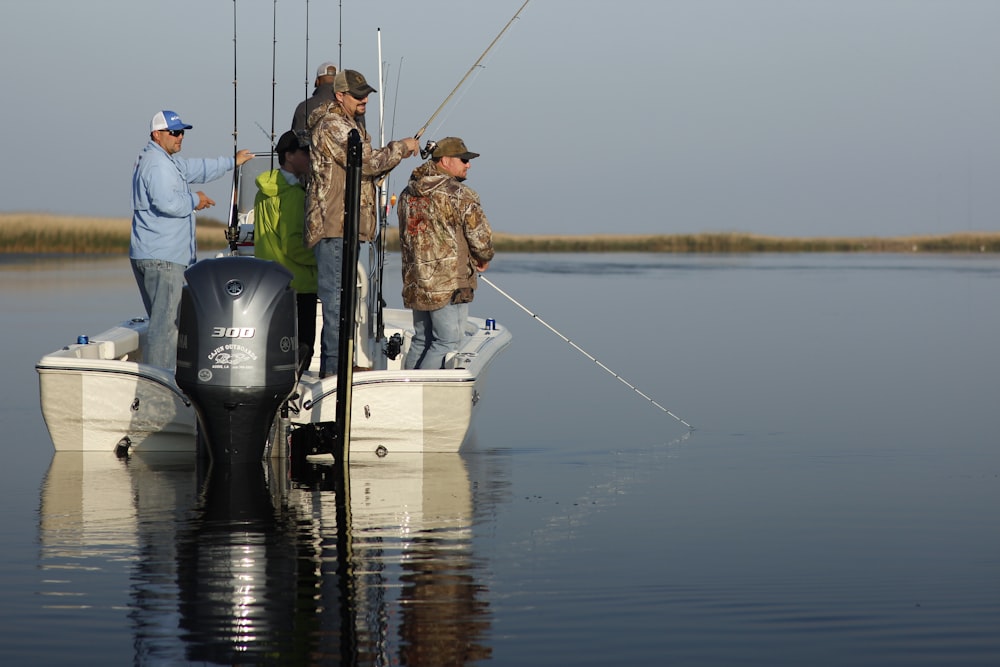 man in blue jacket and black pants standing on white boat during daytime