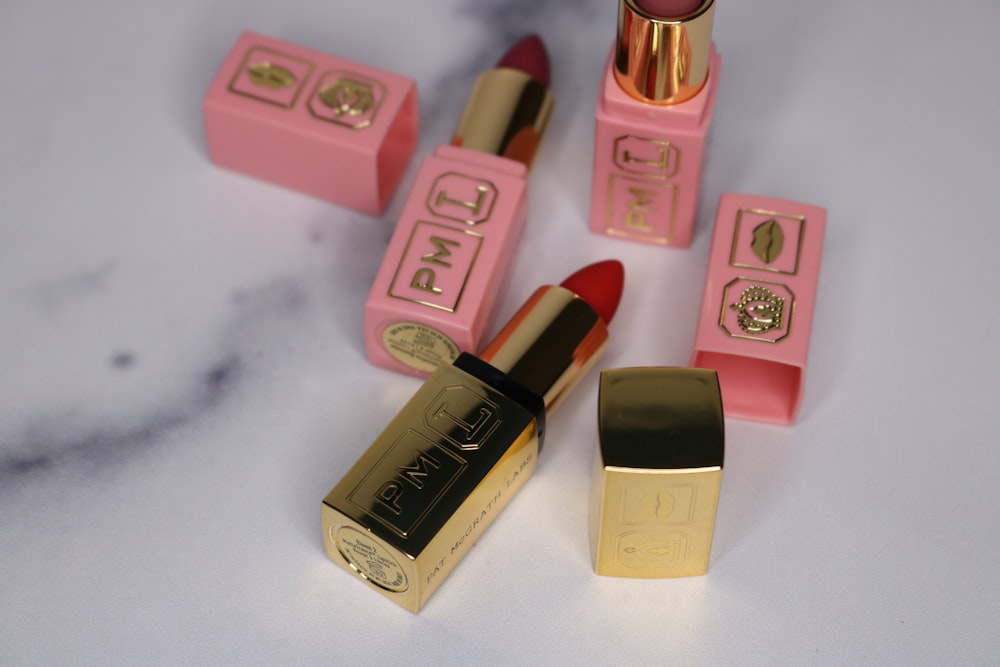 pink and brown lipstick on white table