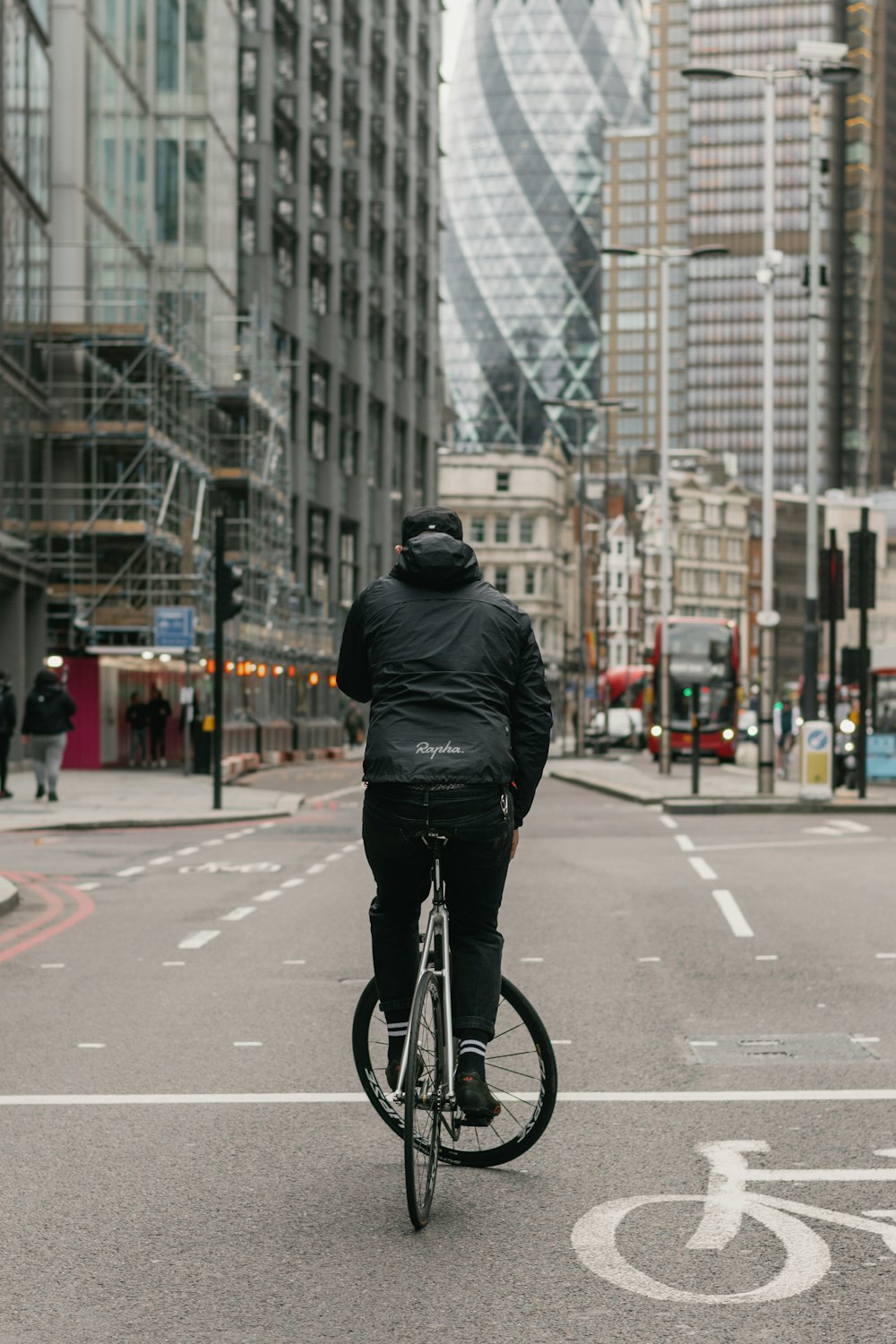 homem na jaqueta de couro preta que monta a bicicleta na estrada durante o dia