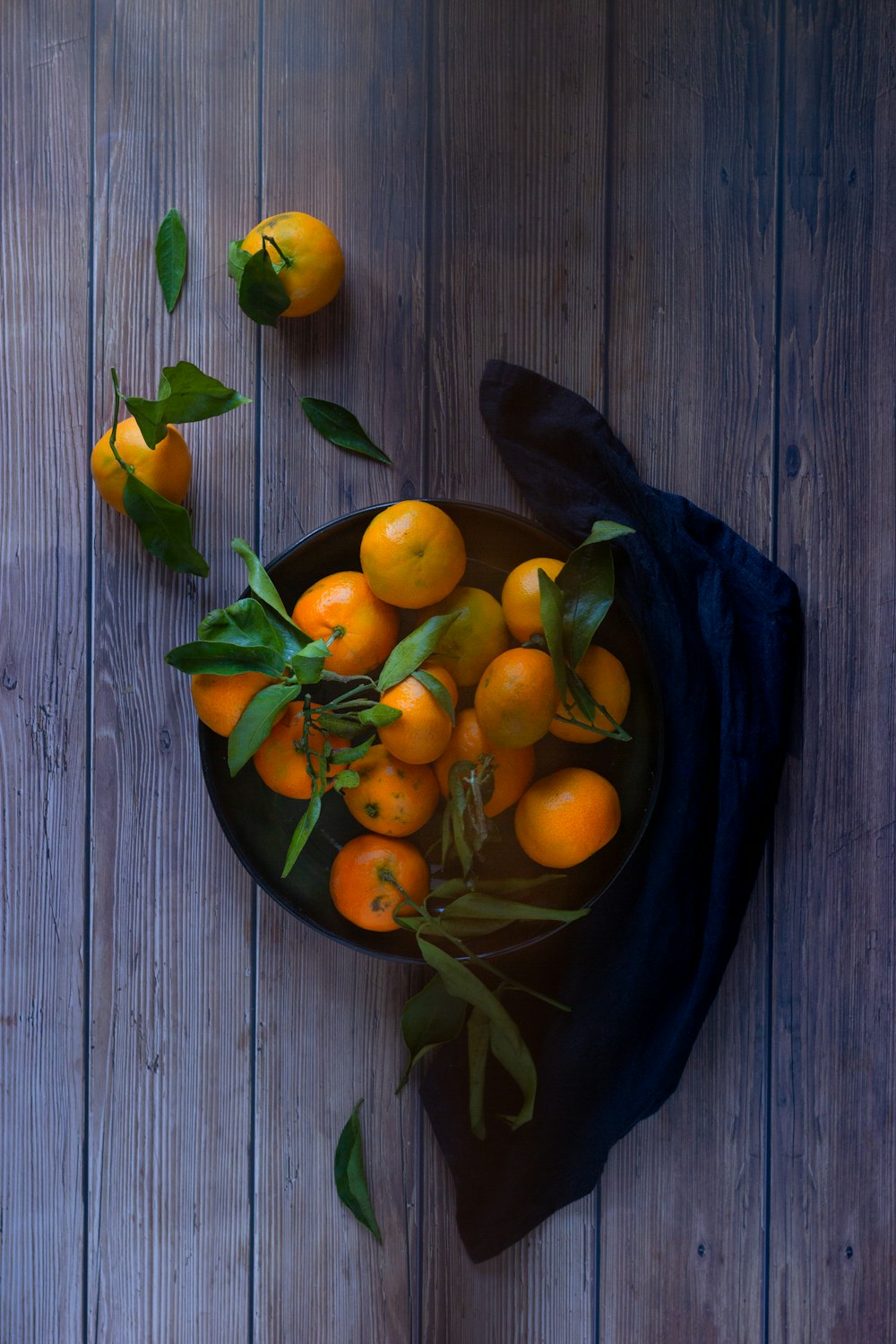 orangefarbene Früchte auf blauer Keramikplatte