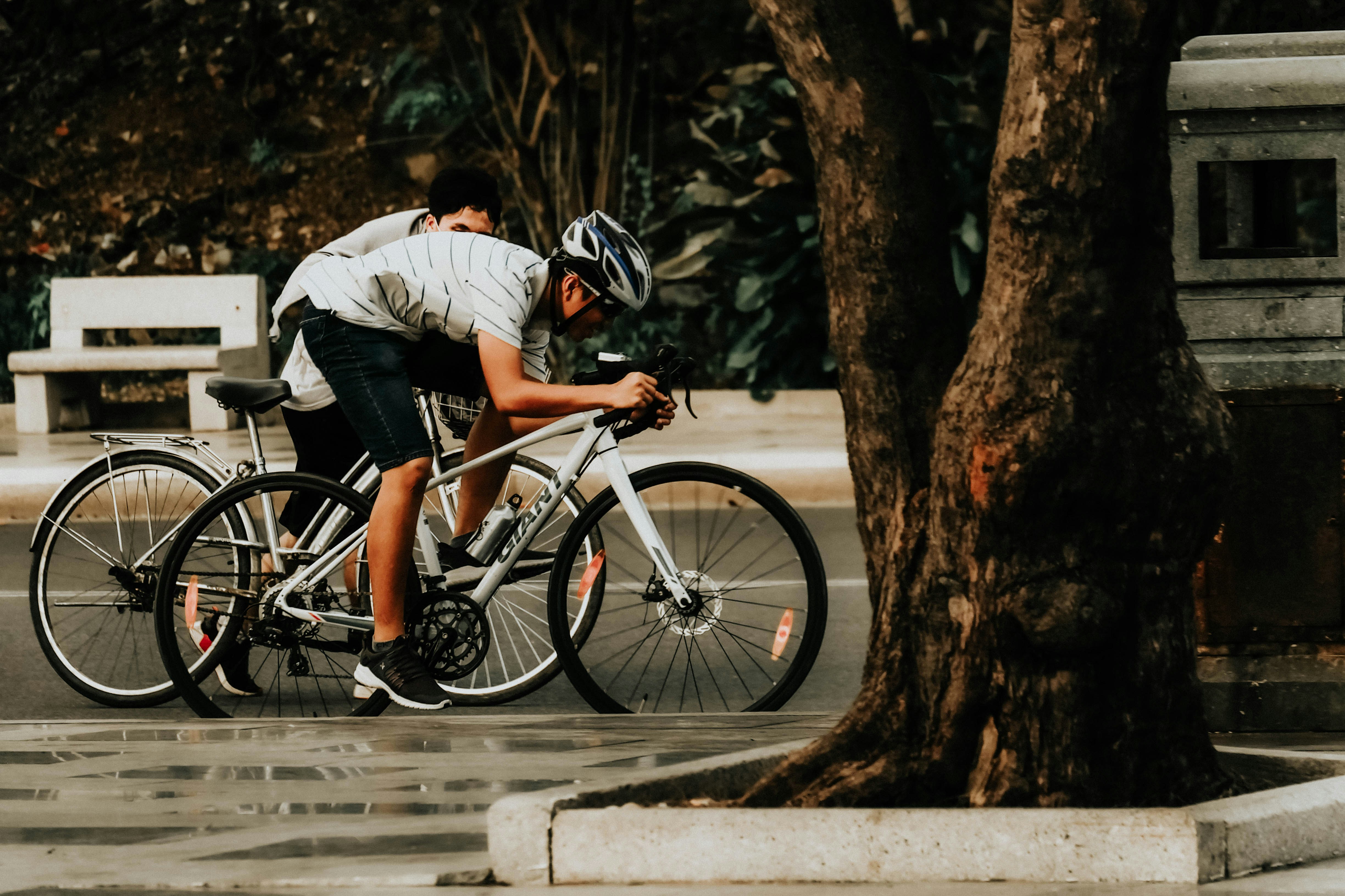 man in white shirt riding black bicycle on road during daytime