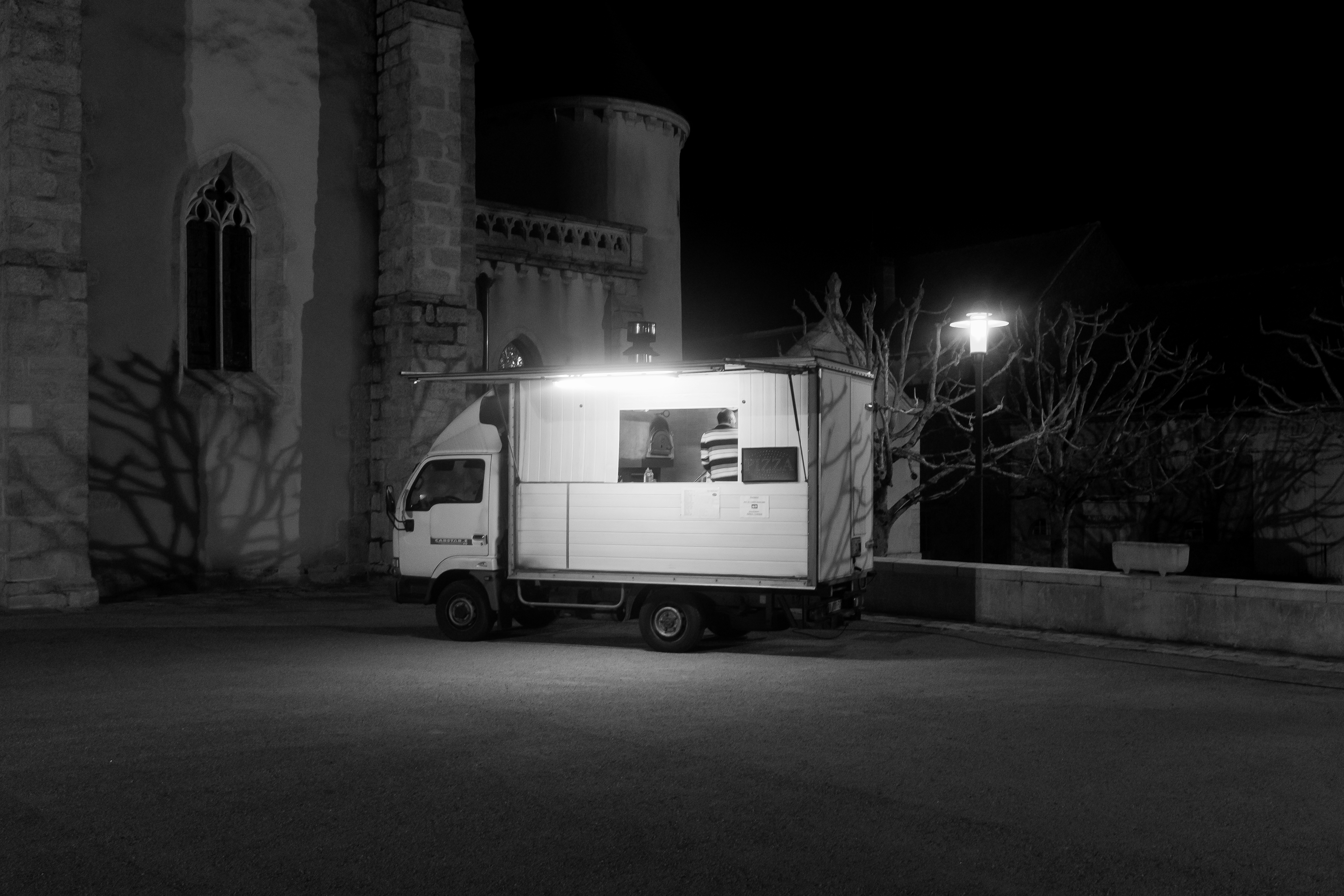 grayscale photo of white van on road