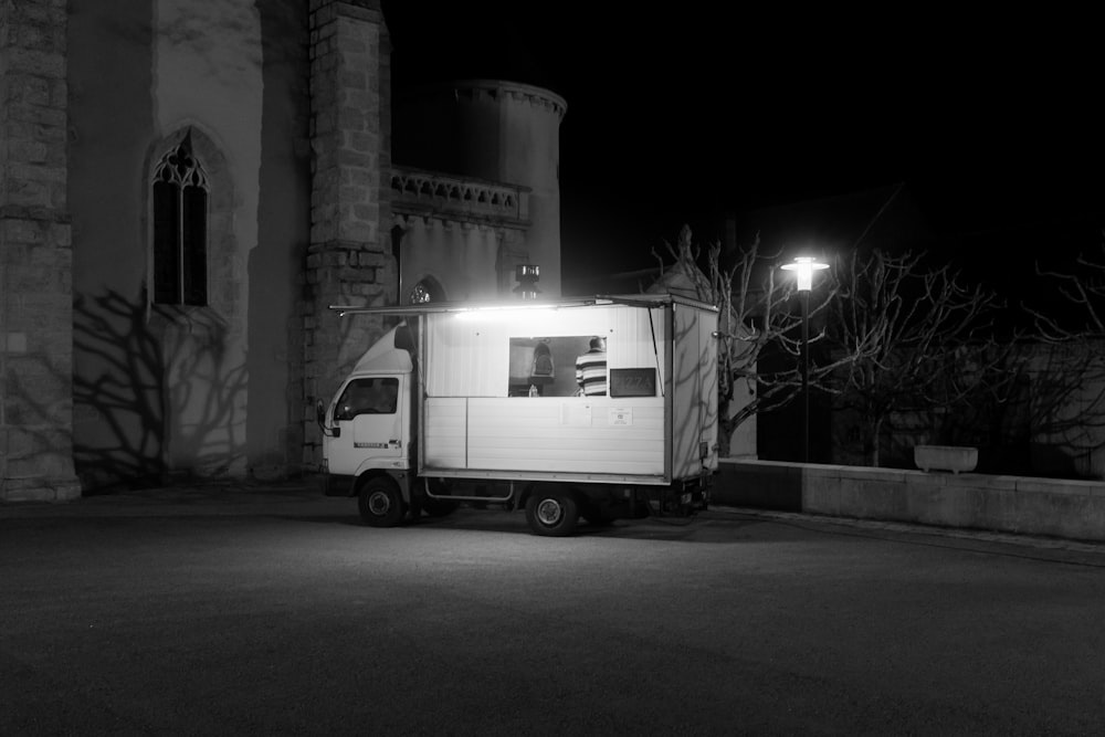 grayscale photo of white van on road