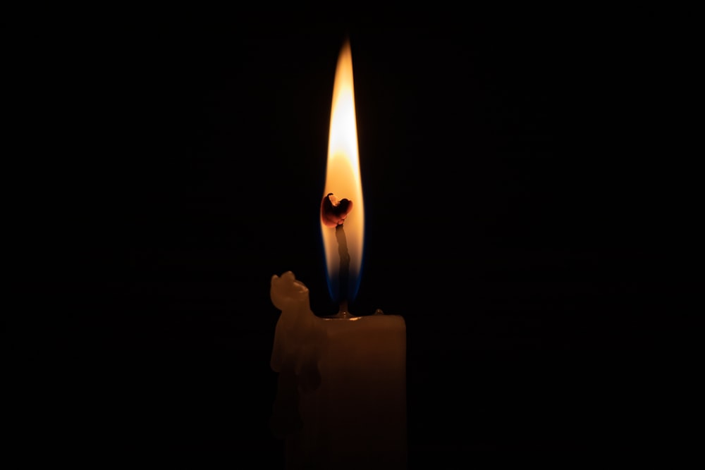 lighted candle in dark room