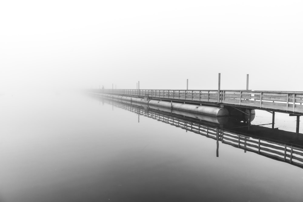 grayscale photo of bridge over body of water