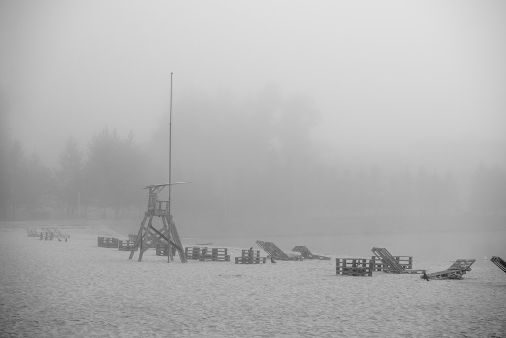 grayscale photo of windmill near body of water