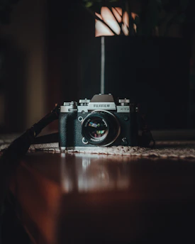 black and silver nikon dslr camera on brown wooden table