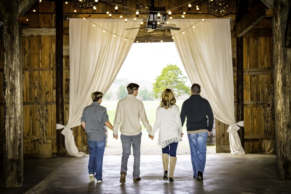 a group of people walking out of a barn