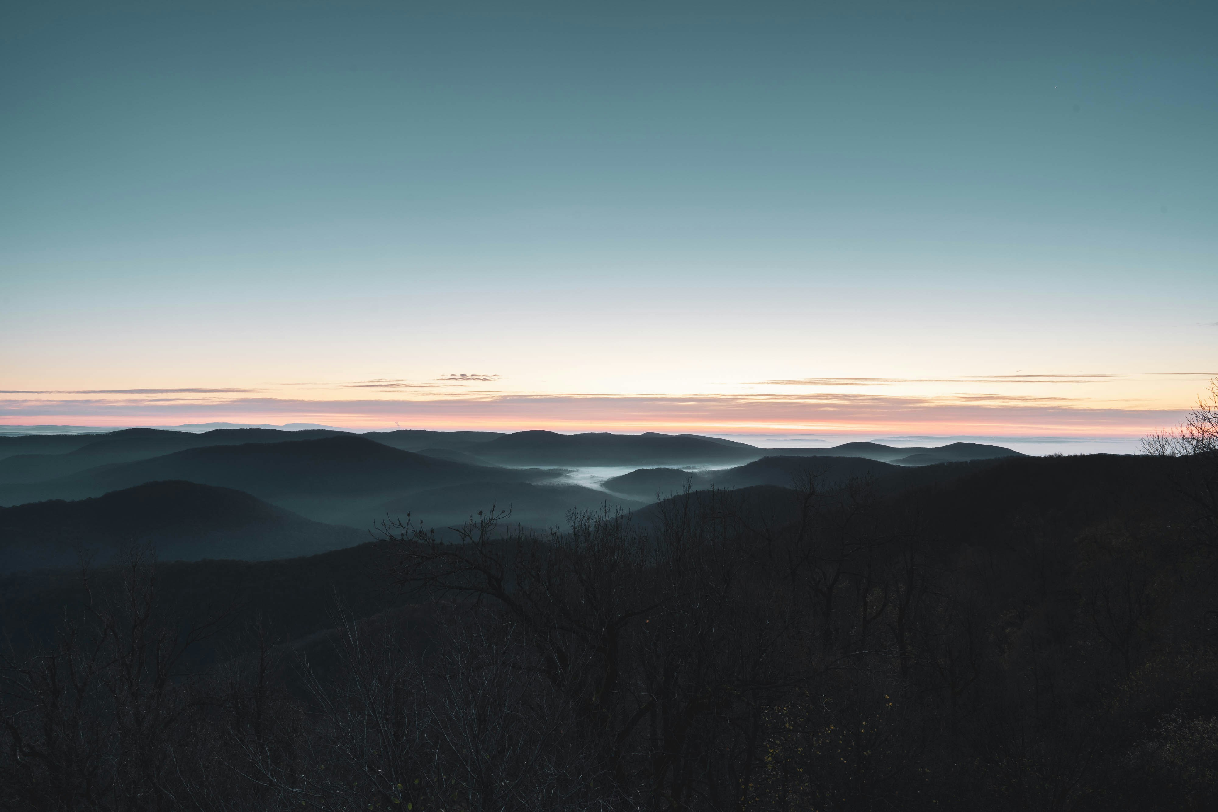 green trees on mountain under blue sky during daytime