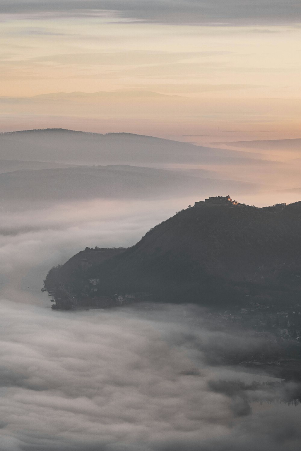 a view of a mountain covered in low lying clouds