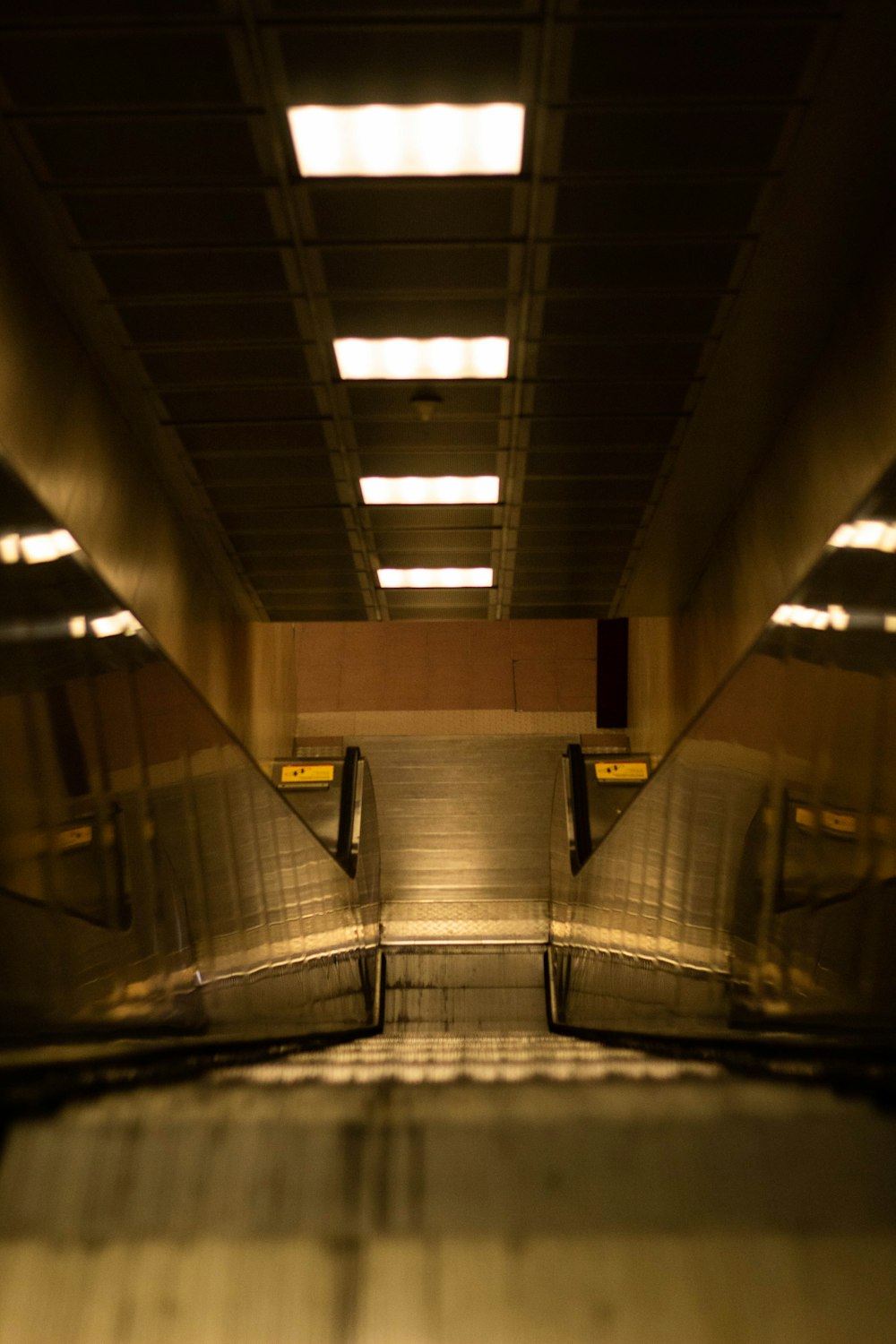 gray and black tunnel with lights turned on during daytime