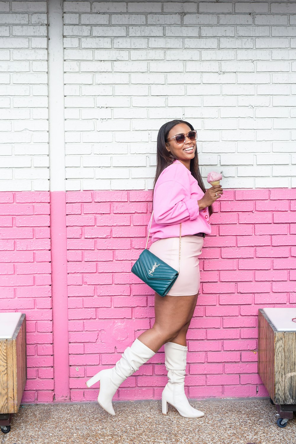 Donna in camicia a maniche lunghe rosa e denim blu Daisy Dukes in piedi accanto a bianco e rosso