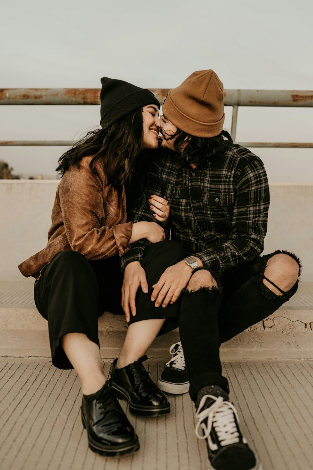 man and woman sitting on concrete floor during daytime