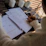 A cheerful woman writing in a colorful budget planner at a cozy kitchen table.