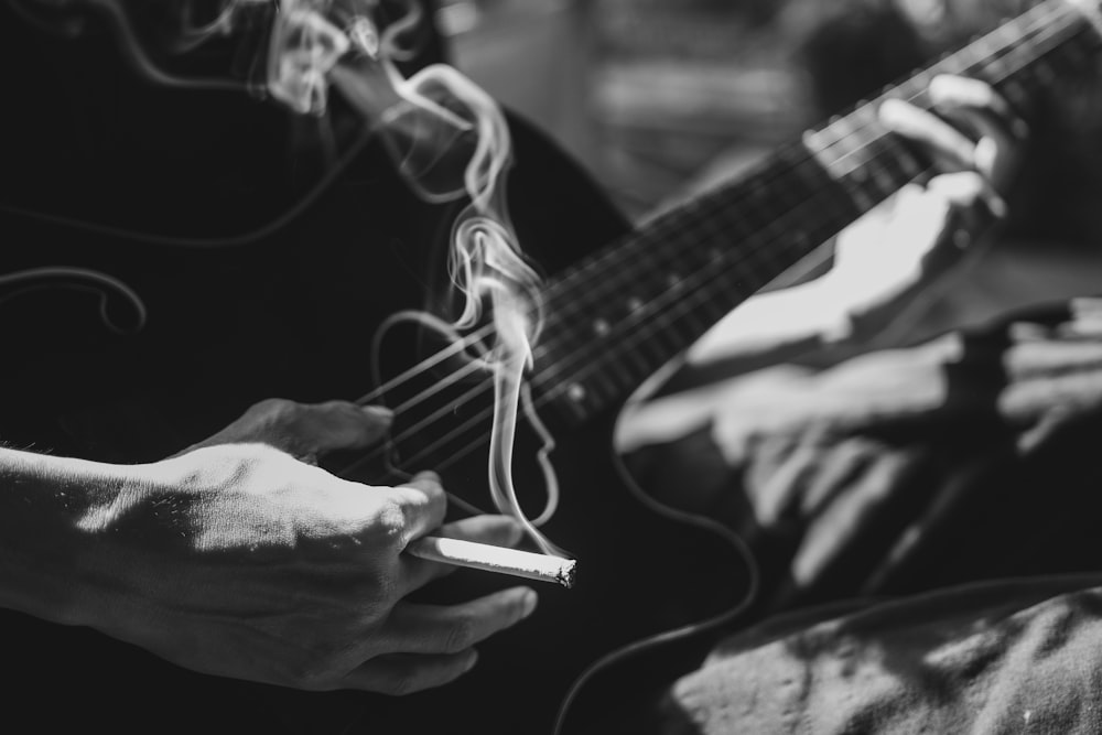 person playing guitar grayscale photo