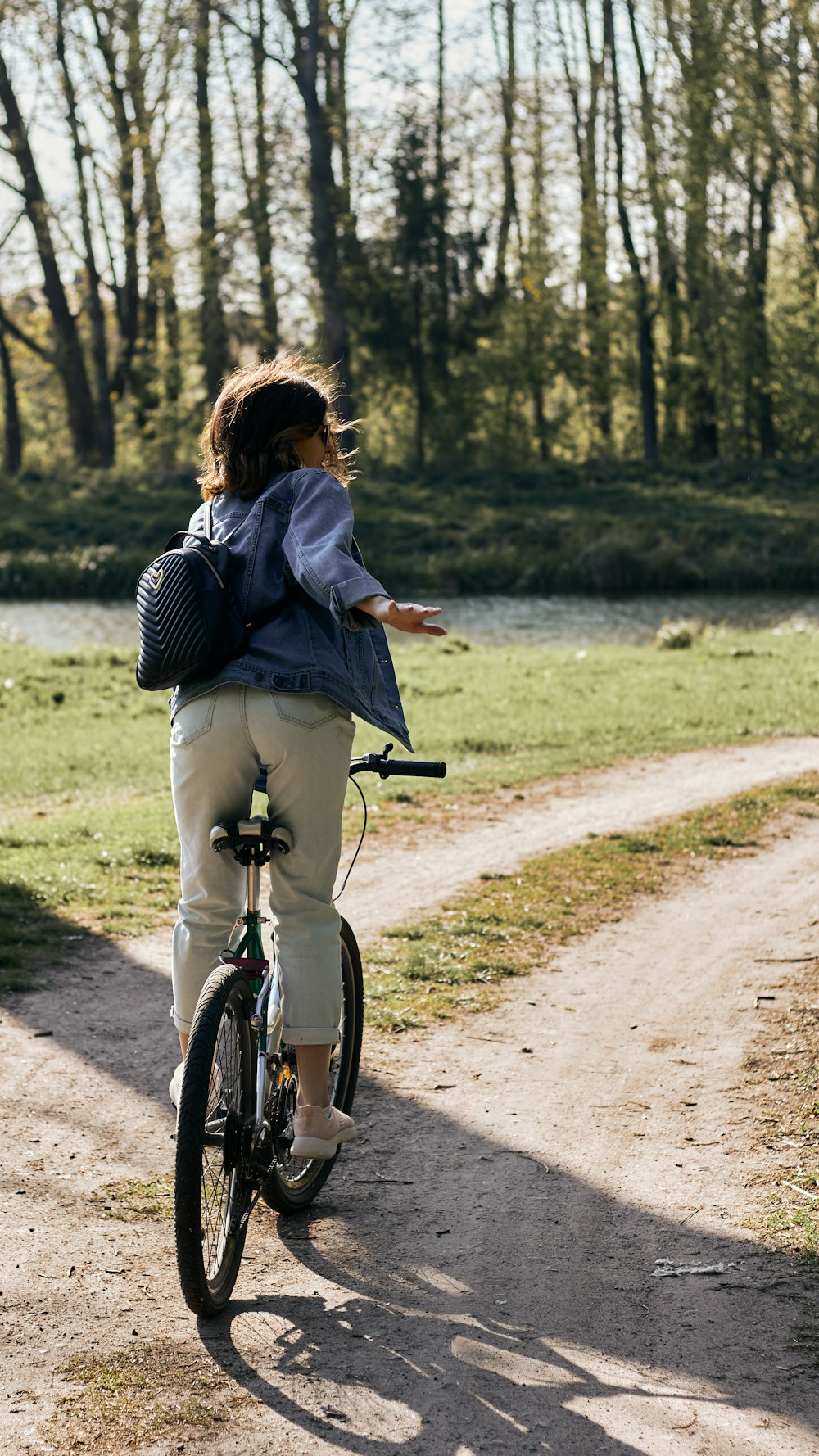 woman in black and white stripe long sleeve shirt riding on bicycle on road during daytime