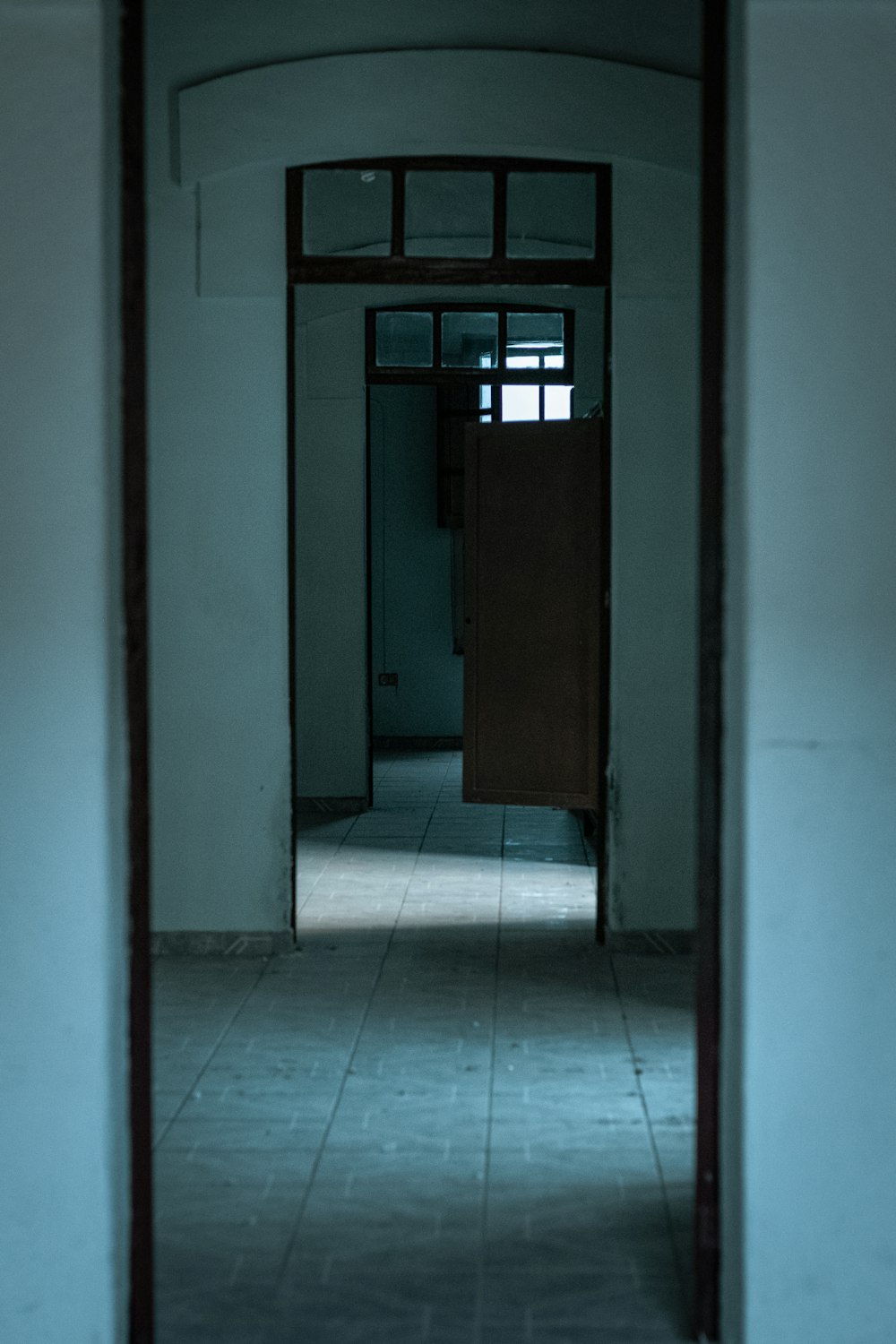 brown wooden door on white and blue ceramic tiles