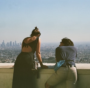 man and woman sitting on concrete bench during daytime