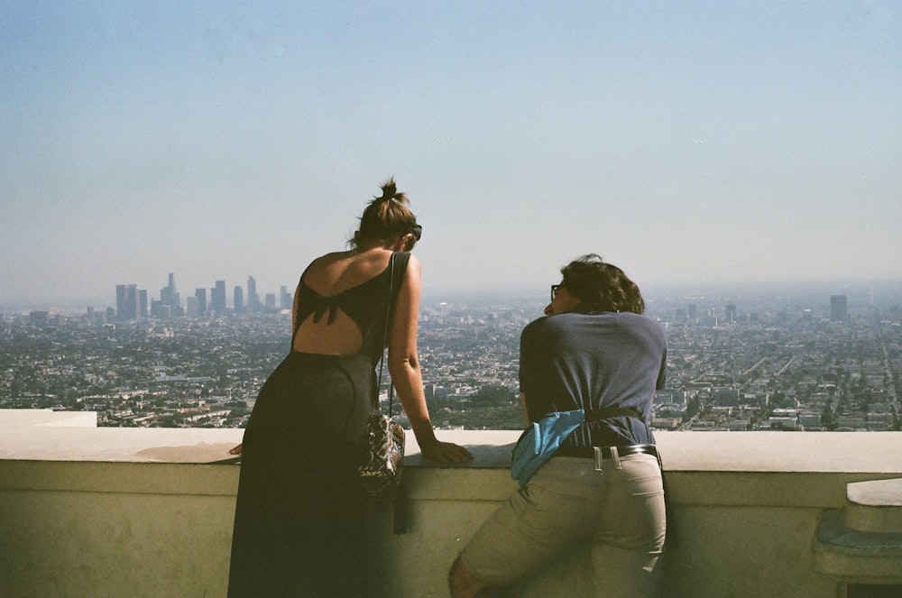 man and woman sitting on concrete bench during daytime