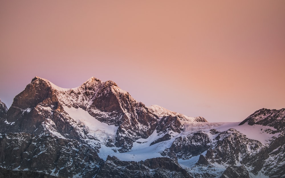 montanha coberta de neve sob o céu azul durante o dia