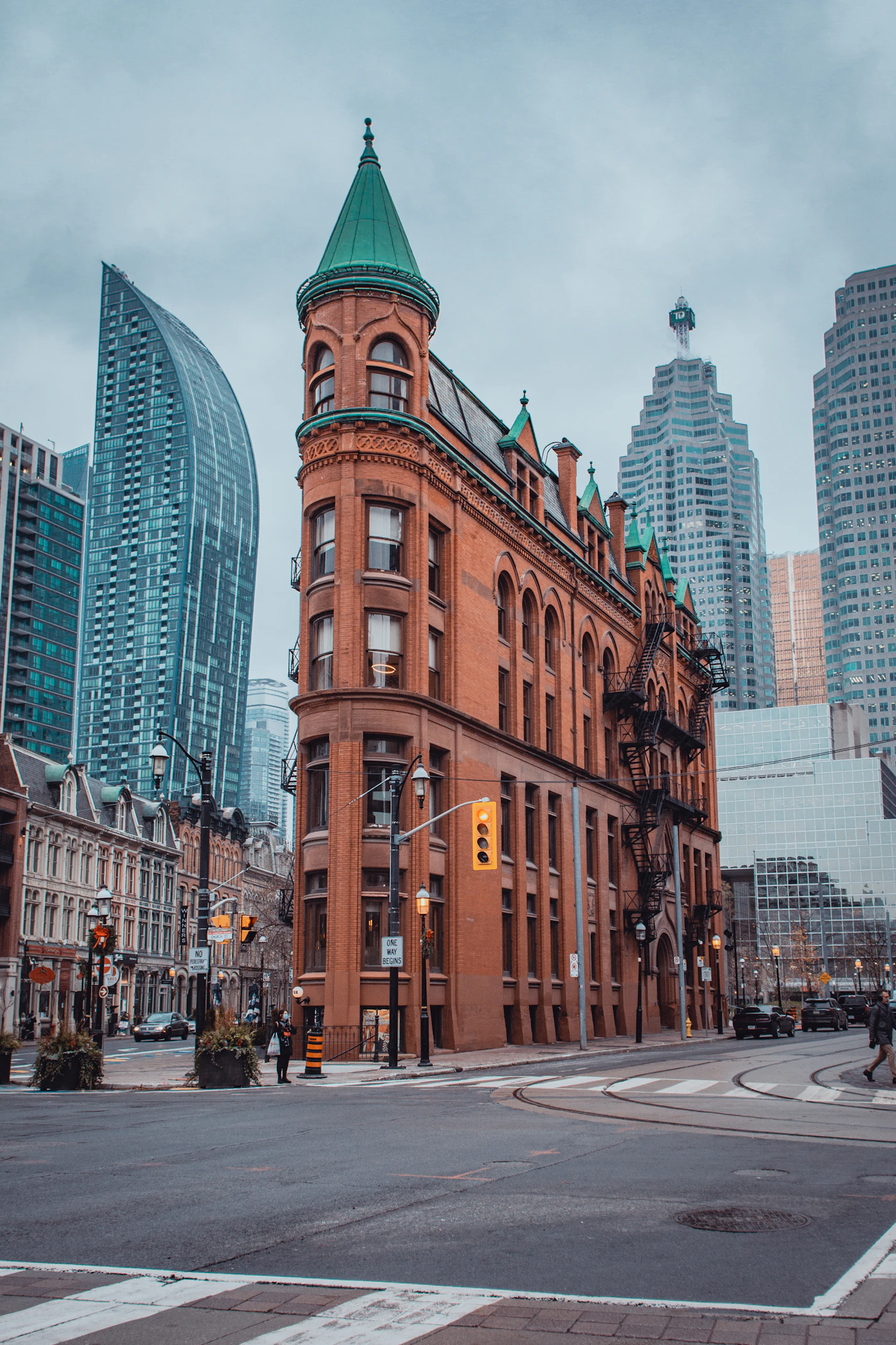 Pedestrians walking past storefronts on a downtown street lined with brick buildings