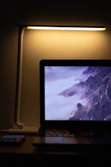 Freelancer sending a signed PDF via email on a laptop with a glowing volcano logo in the background.