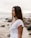 woman in white shirt standing on beach during daytime