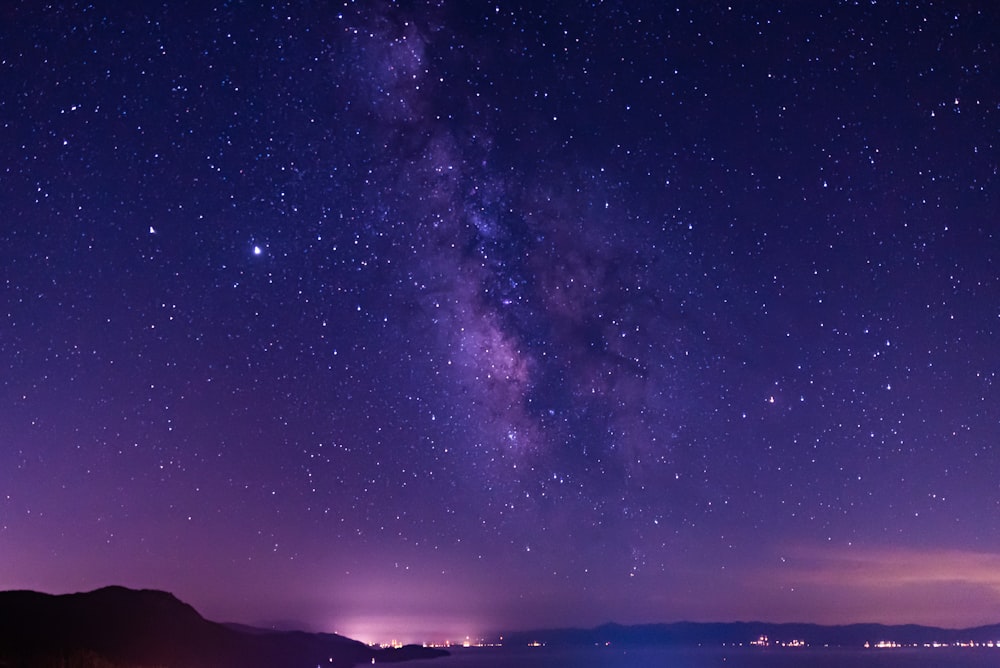 silhouette of mountain under starry night