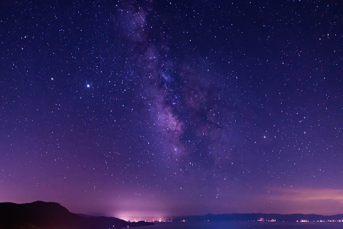 silhouette of mountain under starry night