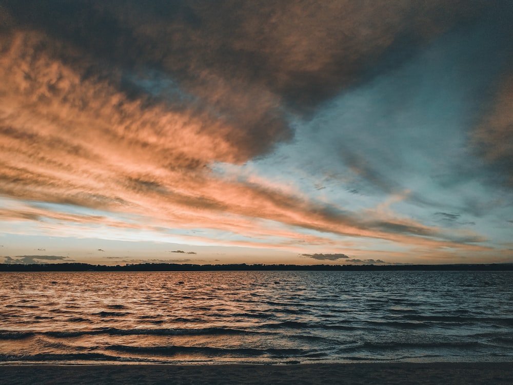 body of water under cloudy sky during daytime