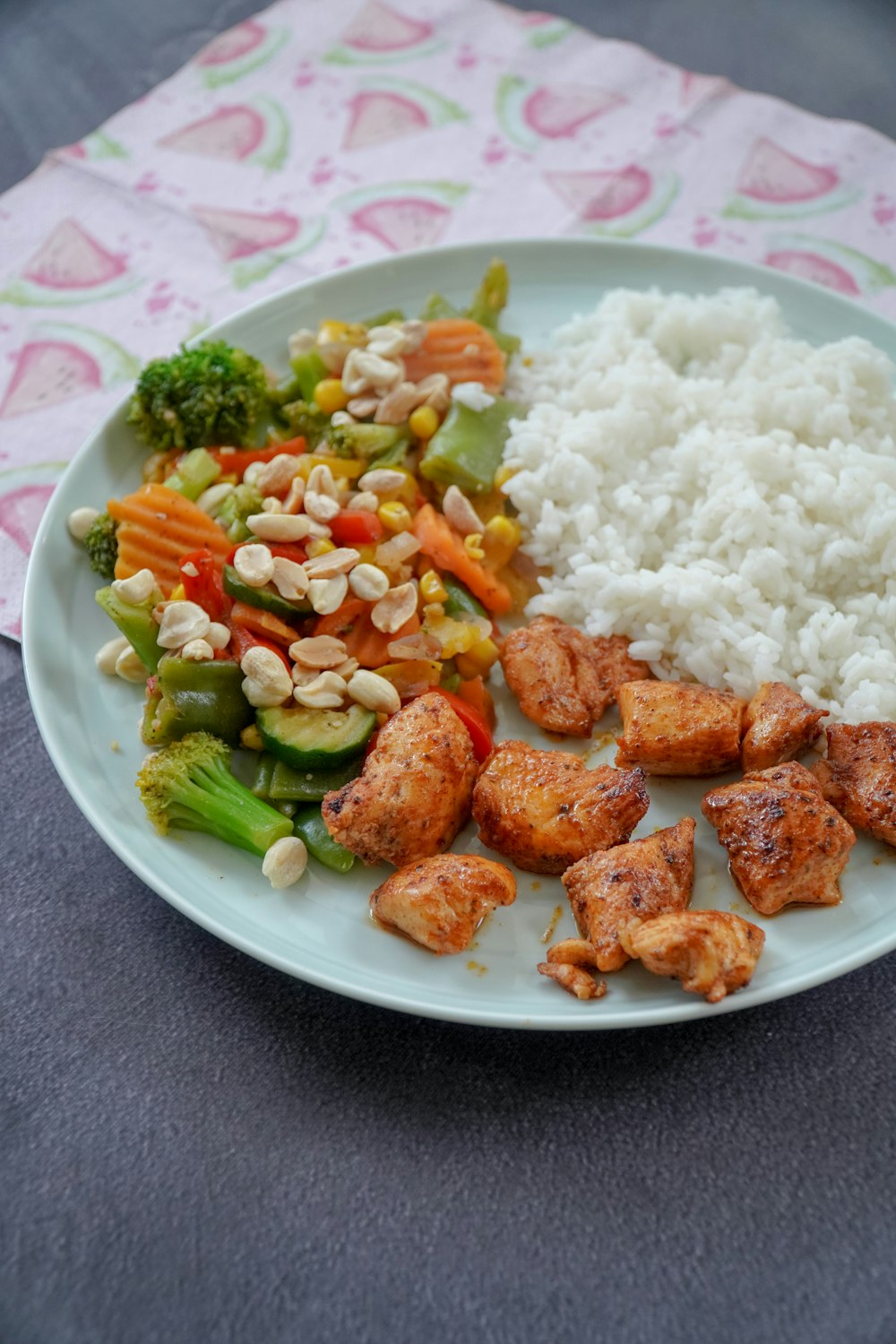 Riz aux légumes tranchés sur assiette en céramique verte